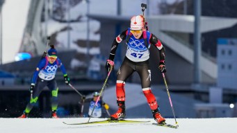 Emma Lunder skis uphill in a biathlon race