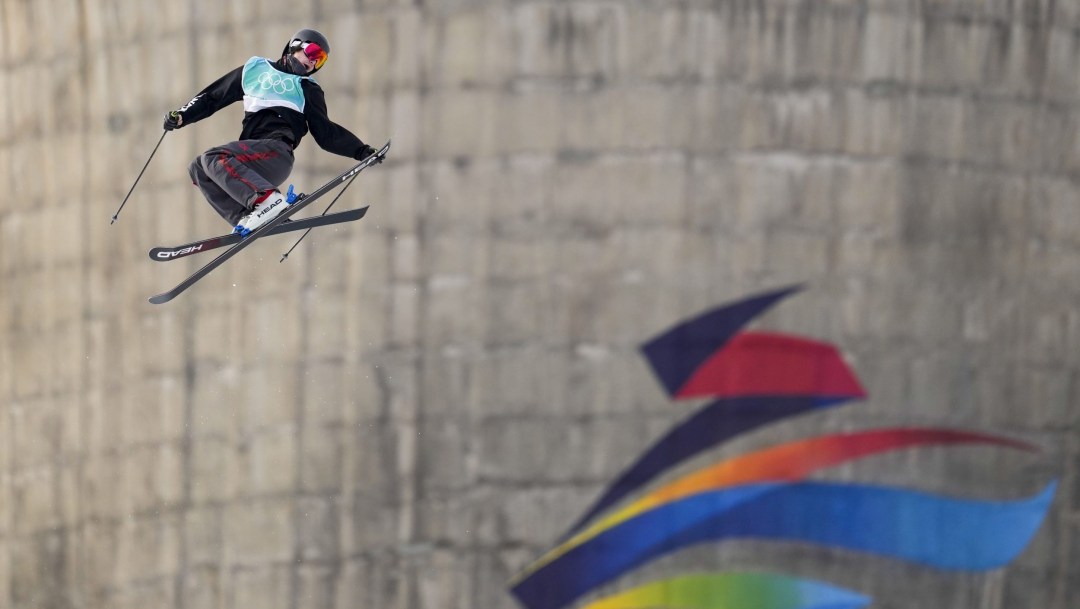 Evan McEachran grabs his ski while performing a mid air trick