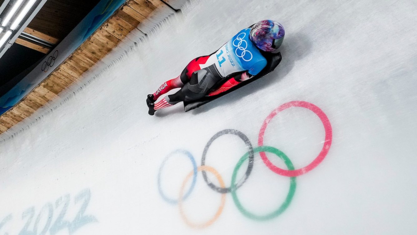 Mirela Rahneva slides past the Olympic rings on the ice track in a skeleton race