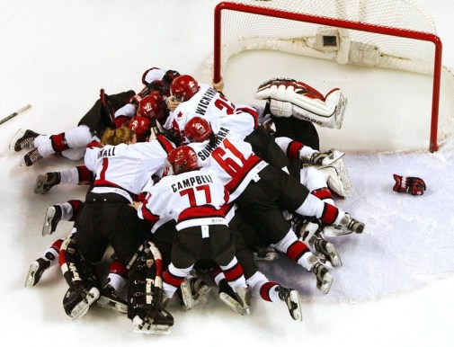 Canadian players pile on one another as the game ends in their victory