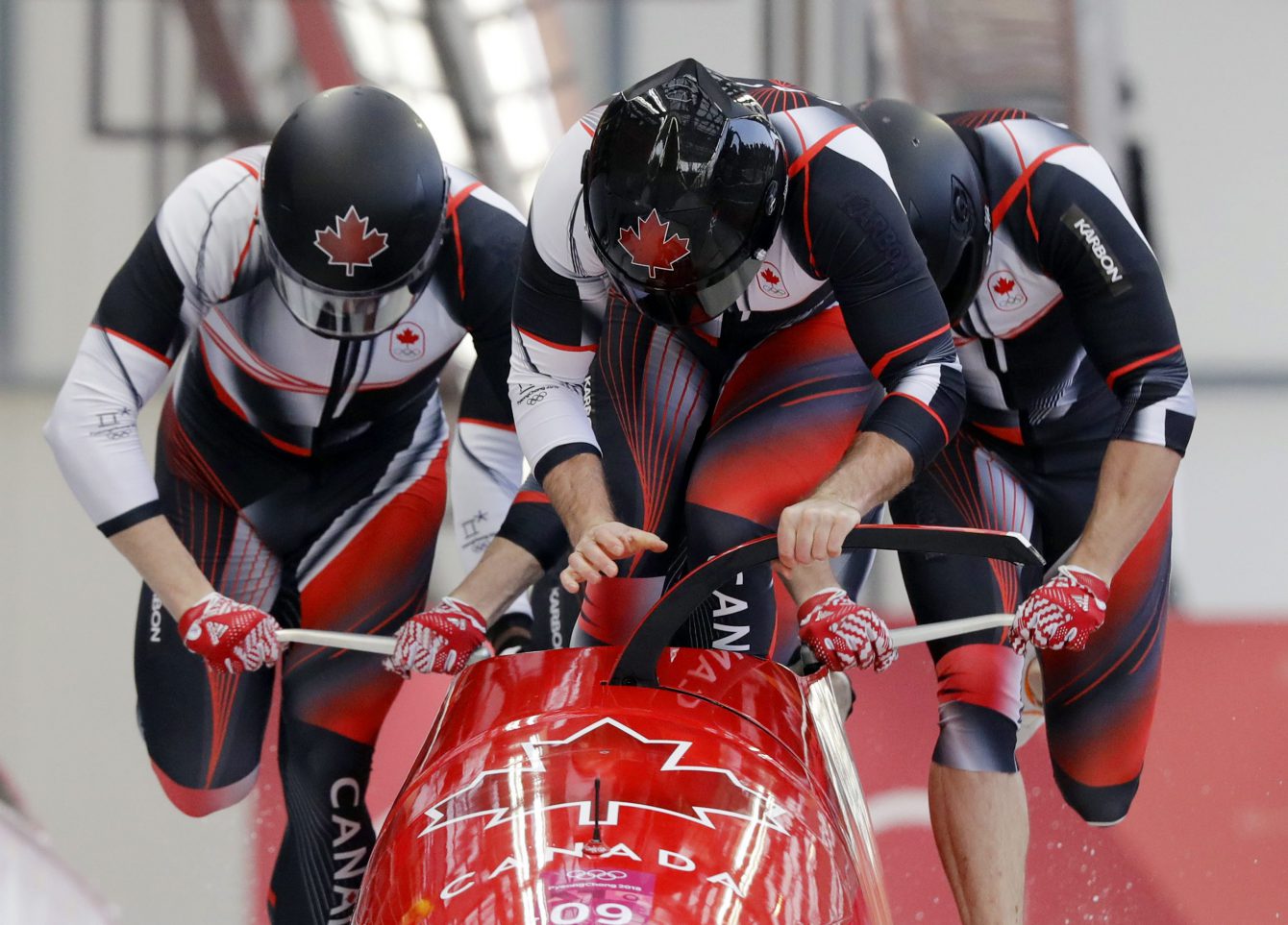 Driver Justin Kripps, Jesse Lumsden, Alexander Kopacz and Oluseyi Smith of Canada start their third heat during the four-man bobsled competition final at the 2018 Winter Olympics in Pyeongchang, South Korea, Sunday, Feb. 25, 2018. (AP Photo/Wong Maye-E)