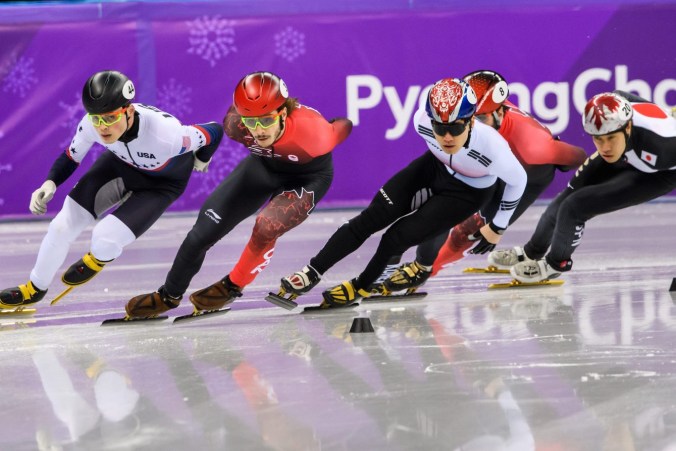 Four short track speed skaters racing