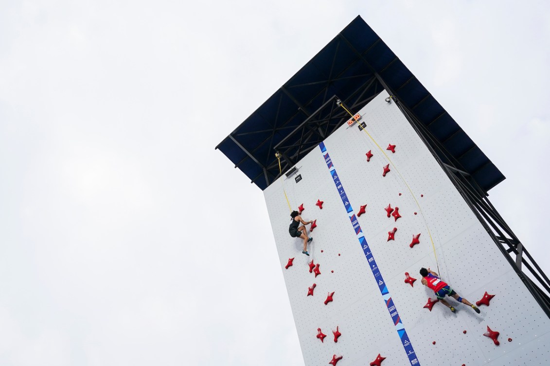 Wide shot of a speed climbing wall with two competitors almost at the top 