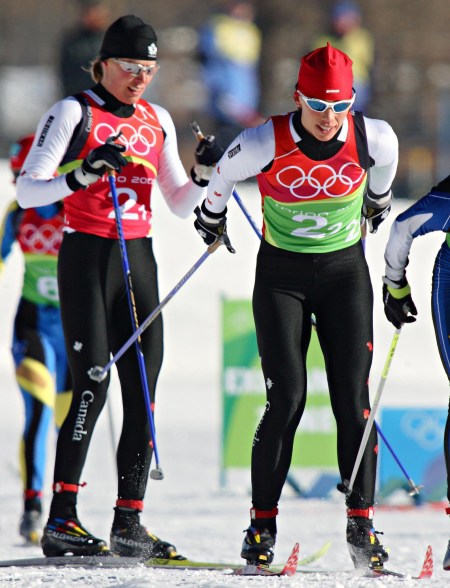 Beckie Scott (right) of Vermillion, Alberta skiis away after being tagged by Sara Renner (left) of Canmore, Alberta in women's team sprint cross-country skiing competition at the Olympic Games in Pragaleto Plan, Italy on Tuesday, February 14, 2006.(CP PHOTO/Frank Gunn)