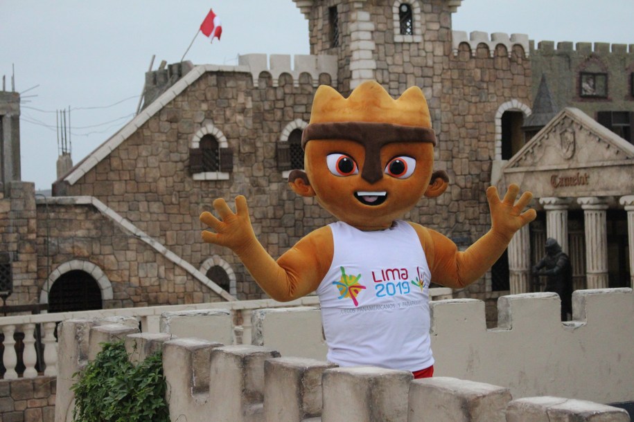 The Lima mascot standing in front of a castle like building
