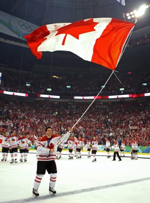 Sidney Crosby carries the Canadian flag on a long pole