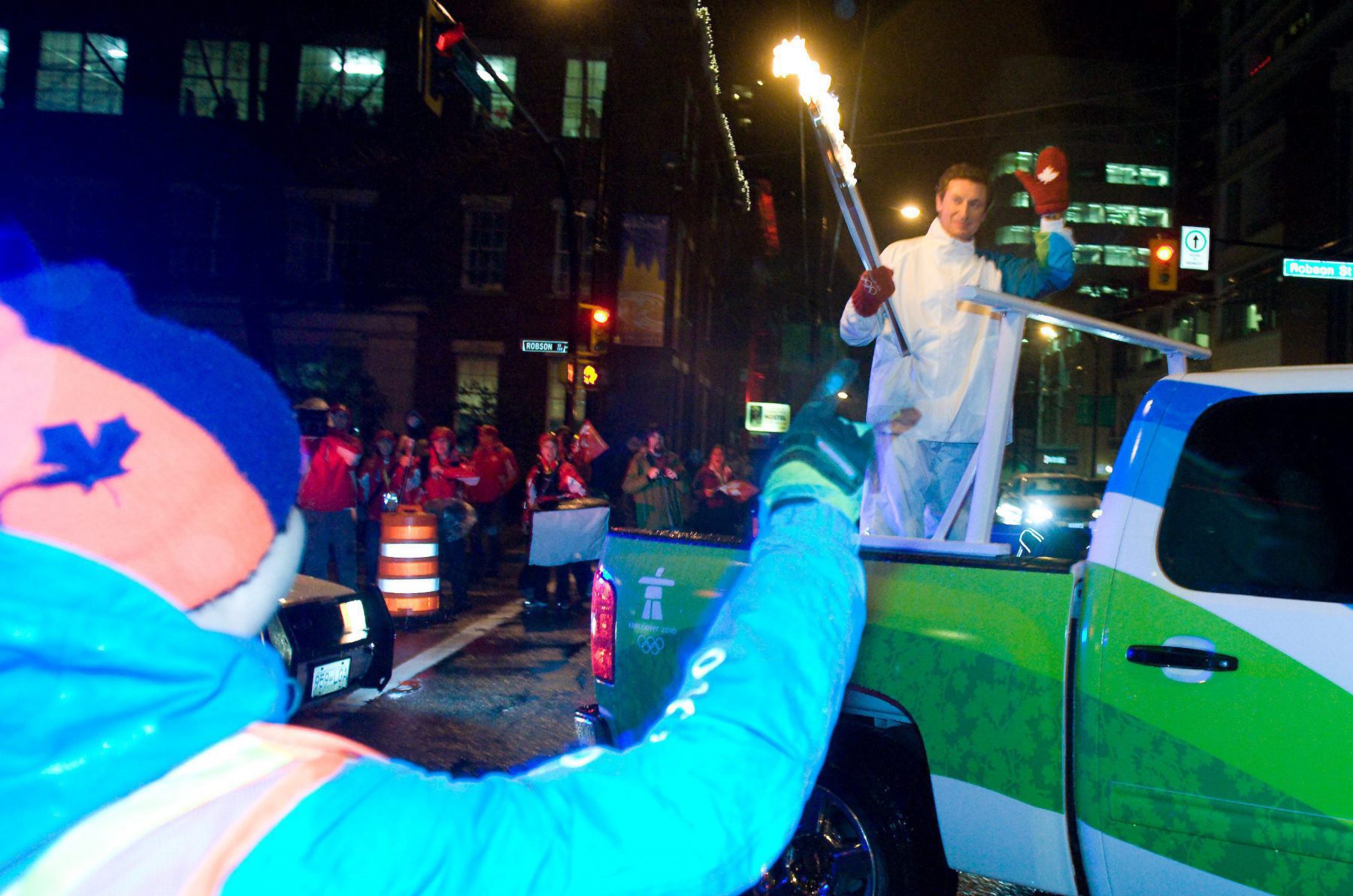 Fans wave to Wayne Gretzky as he leaves B.C. Place with the Olympic Torch in Vancouver, B.C., Friday, Feb. 12, 2010 following the Opening Ceremony of the 2010 Vancouver Winter Olympic Games. THE CANADIAN PRESS/Geoff Howe