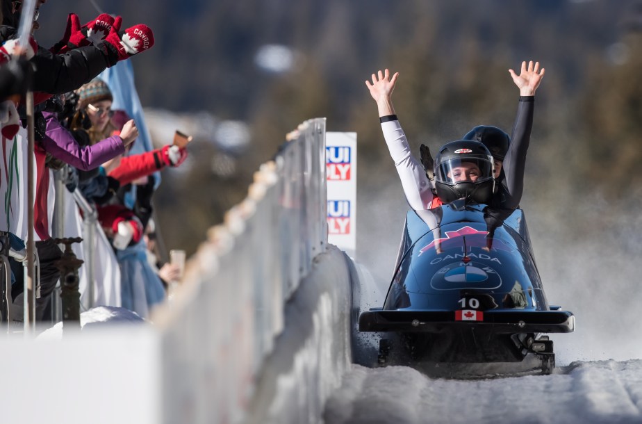 Bobsledders raise their arms at the end of a run