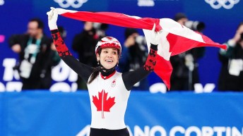 Courtney Sarault waves a Canadian flag above her head