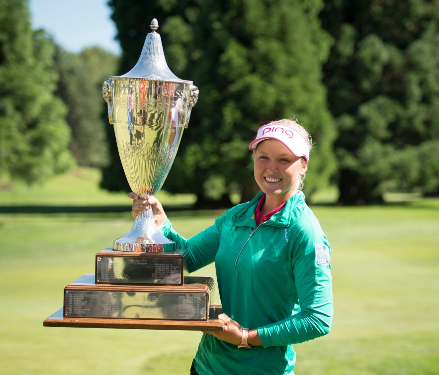 Brooke Henderson holds a big silver trophy 