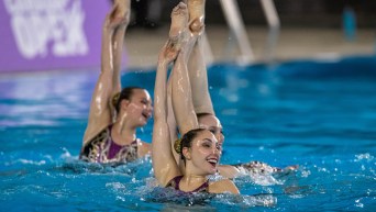 Artistic swimmer performs a routine in the water