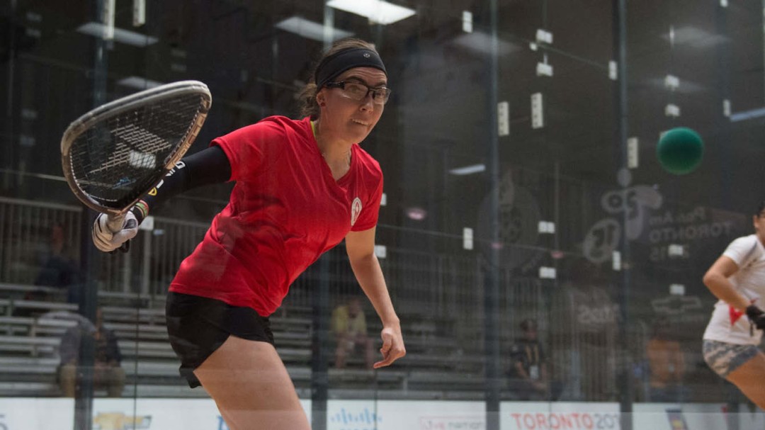 Squash player hits ball