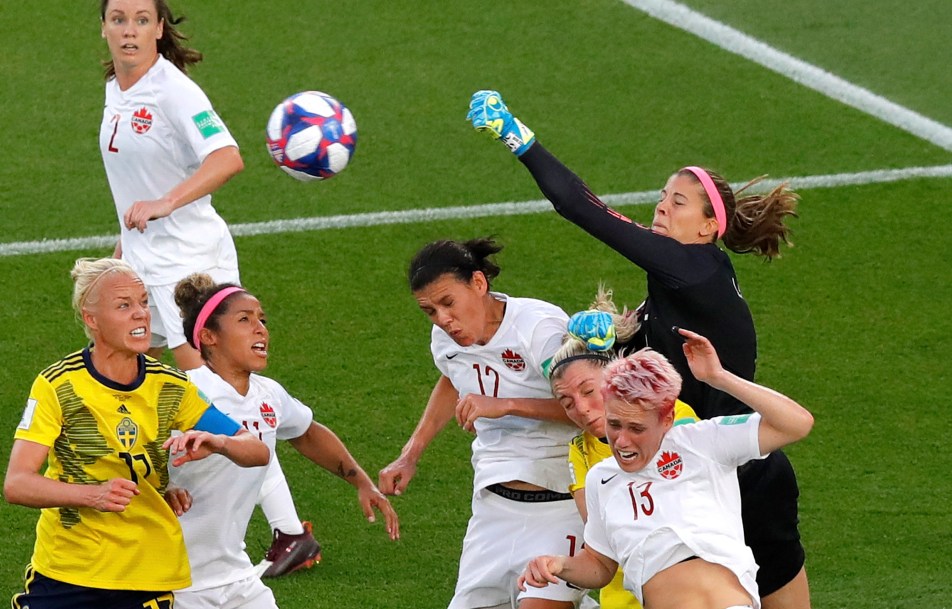 Canada's Stephanie Labbe leaps to punch the ball away.