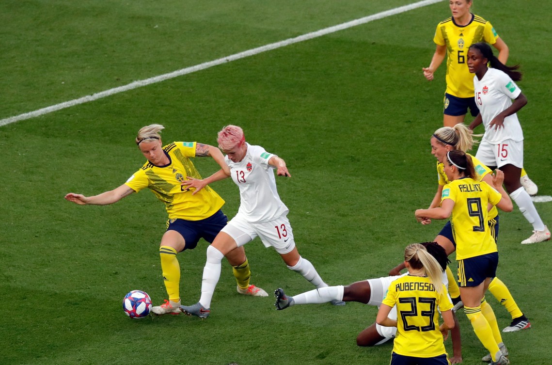 Sweden's Nilla Fischer vies for the ball with Canada's Sophie Schmidt