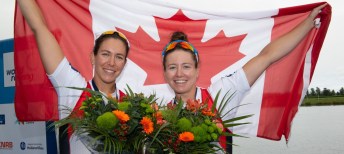 Canadian athletes pose with flag and flowers