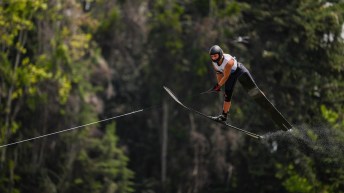 A water skier jumps in the air on two large skis