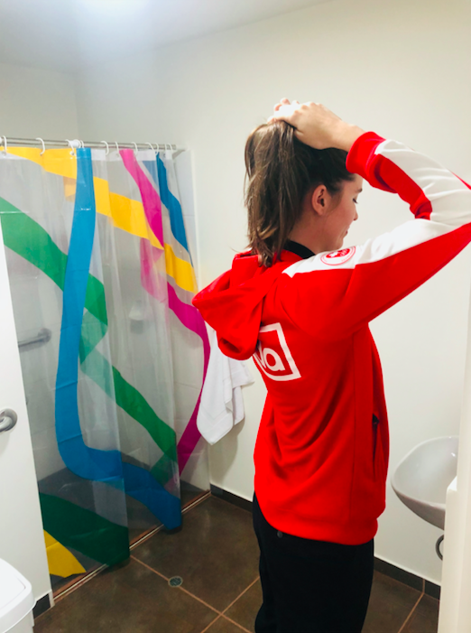 Athlete fixing her hair in bathroom