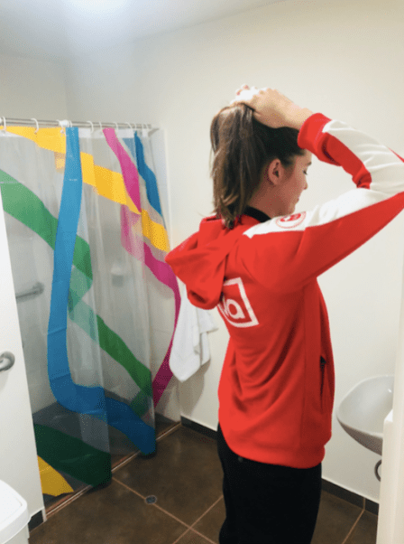 Athlete fixing her hair in bathroom