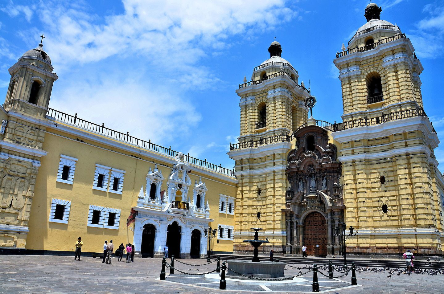 Yellow church with palm trees in front of it