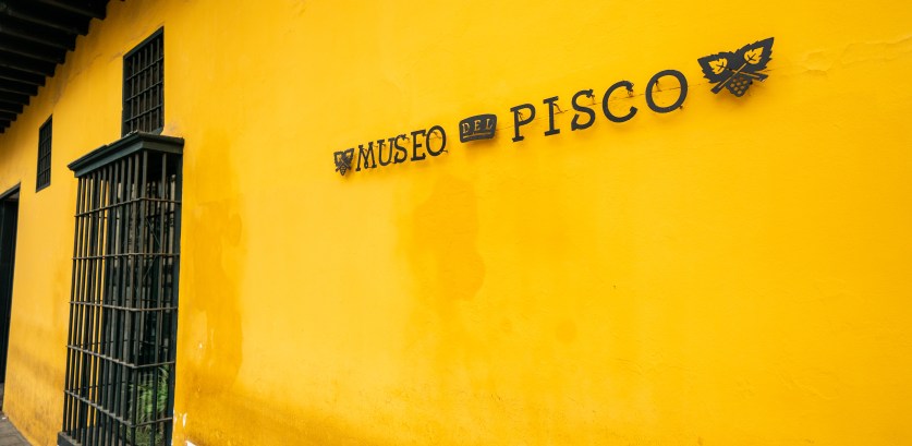Yellow wall with Pisco liquor museum sign