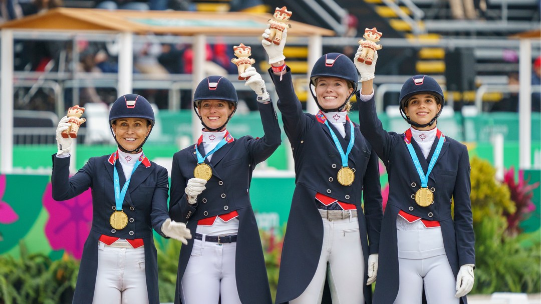 Four equestrian athletes hold up figurines