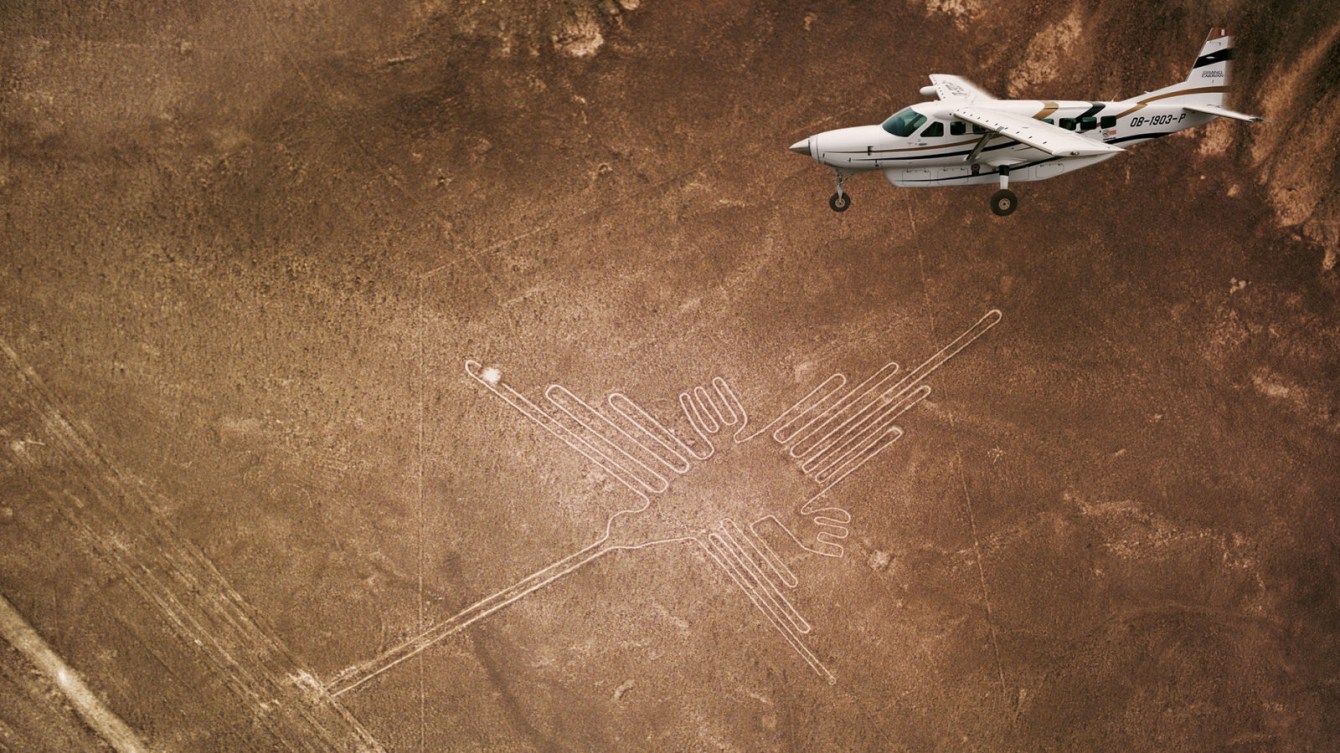 Airplane flying over Lines on the ground shaping a figure