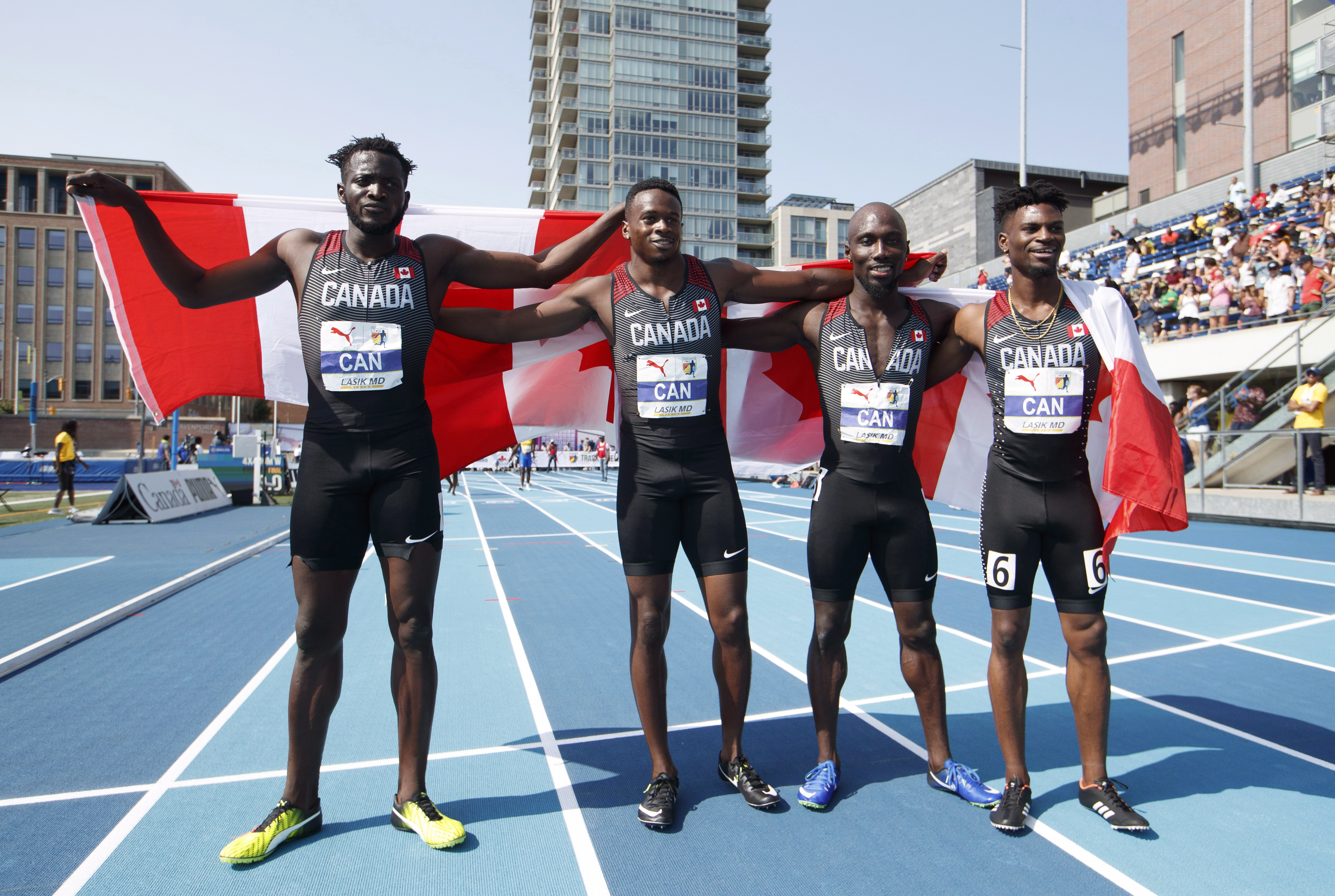 Sprinters pose with the Canadian flag