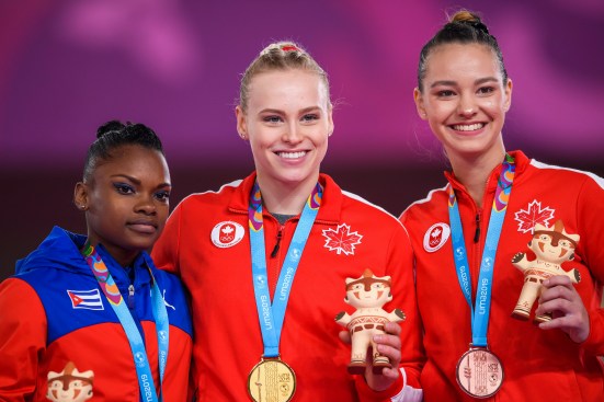 Three women pose with their gold, silver and bronze medals