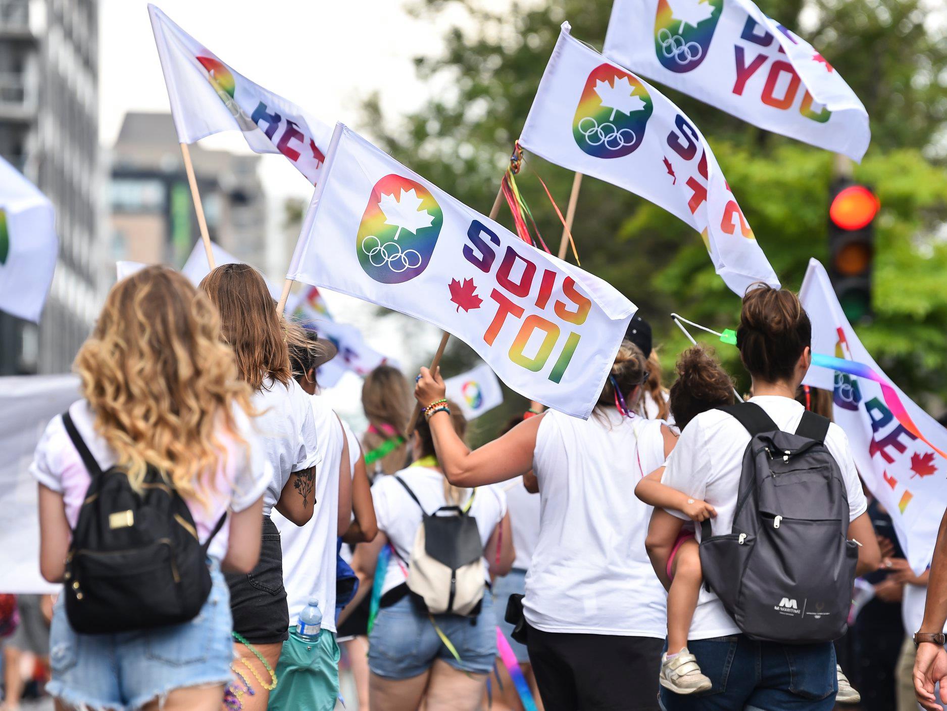 People waving flags at You Can Play event