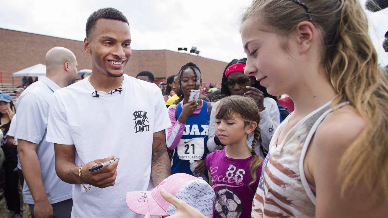 Andre De Grasse signs a young girl's hat