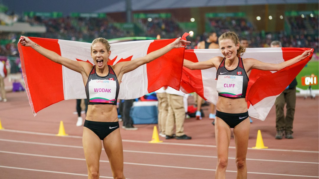 Two Canadian athletes celebrate with flags
