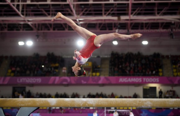 team-canada-artistic-gymnastics gymnast does a backflip on beam