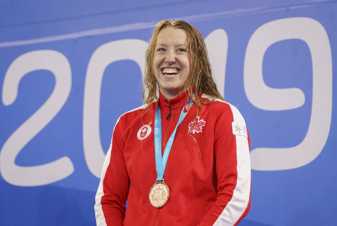 athlete smiles with a bronze medal around her neck