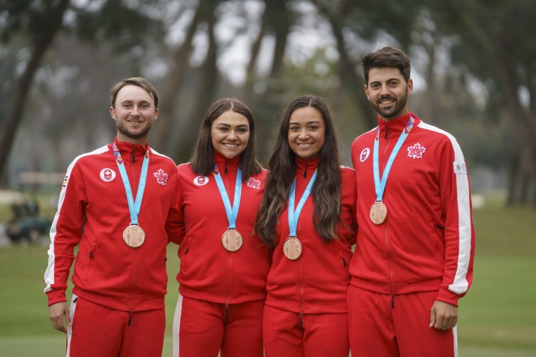 four athletes pose with their medals