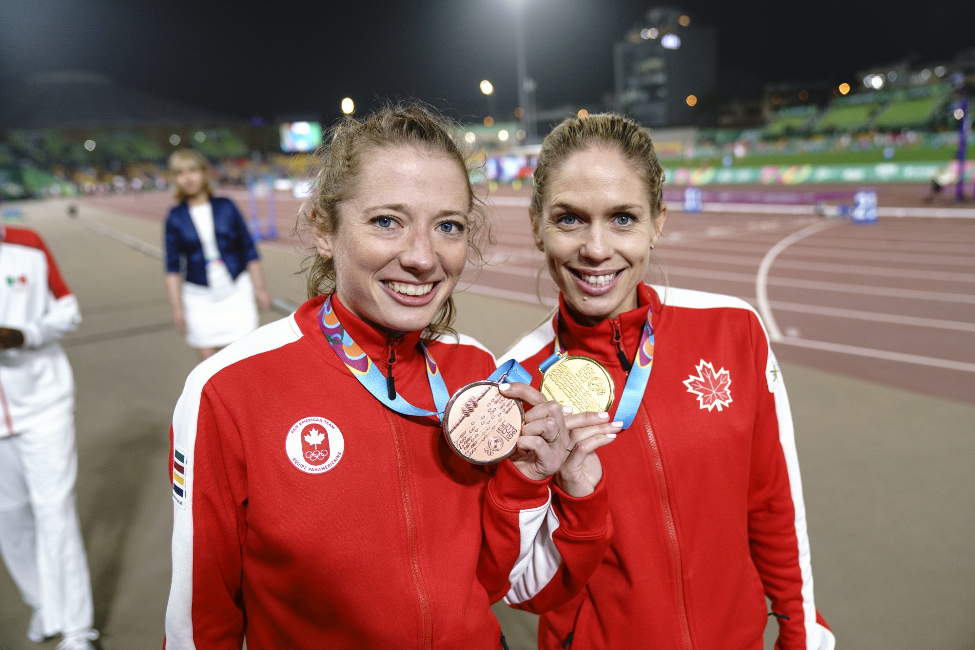 two athletes hold up their medals