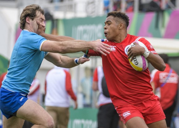 team-canada-rugby rugby player blocks a tackle from player on another team
