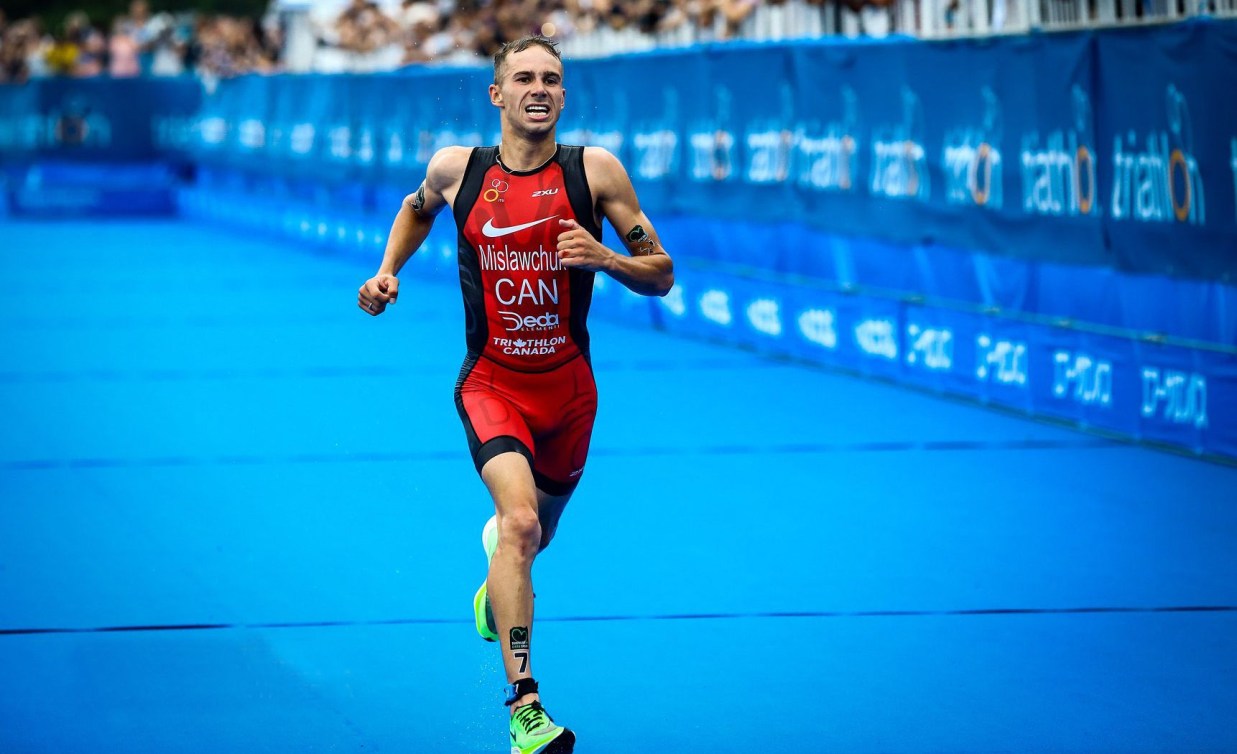 Il triatleta Tyler Mislawchuk corre verso il traguardo del test event di Toyko 2020.