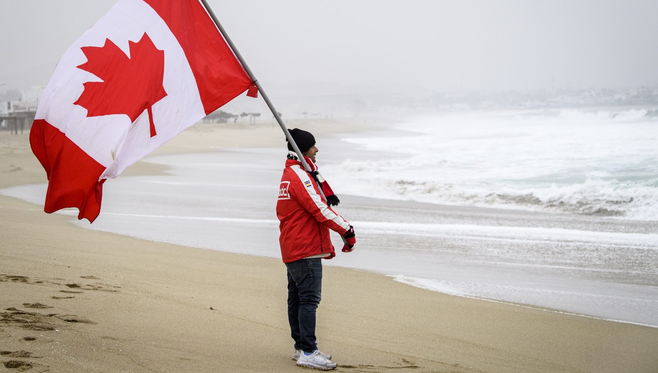 Team Canada coach holding a Canadian flag
