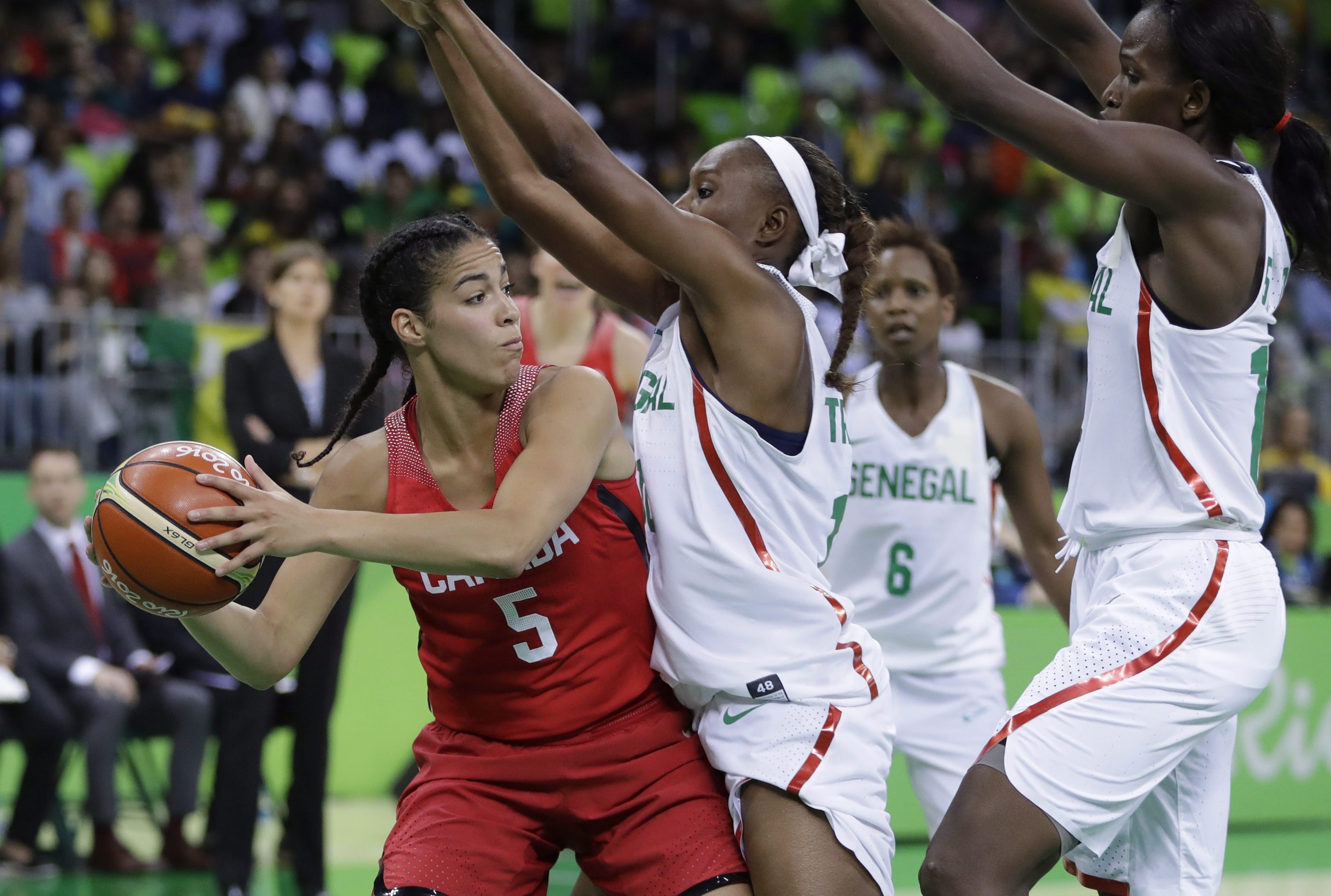 Kia Nurse holds the ball as she tries to get around two members of the Senegal team.
