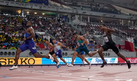 Christian Coleman, of the United States, crosses the line ahead of Aaron Brown, of Canada, and Adam Gemili, of Great Britain