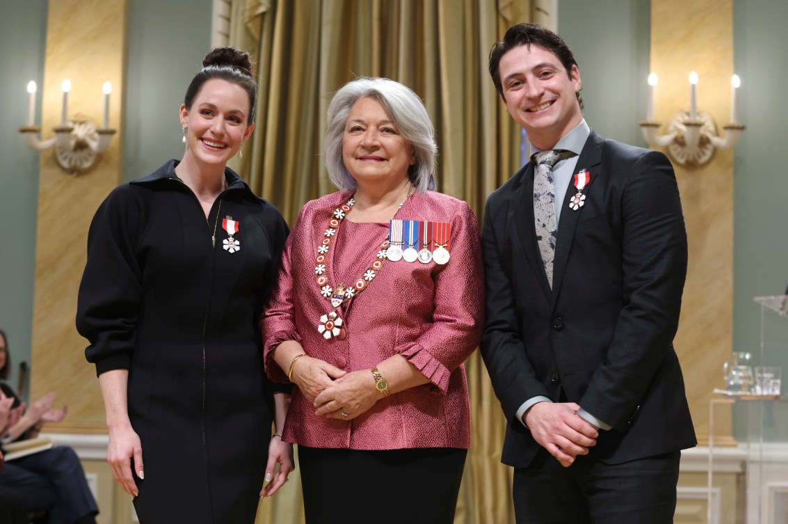 Tessa Virtue and Scott Moir stand alongside Governor General Mary Simon while wearing their order of Canada insignia 