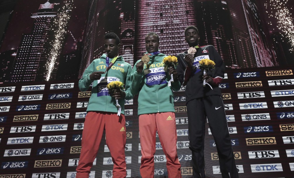 Muktar Edris (centre), Selemon Barega (left), and Mohammed Ahmed (right) receive their medals.