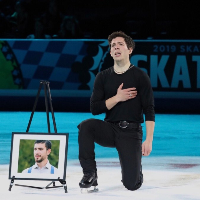 Keegan Messing kneels beside a picture of his late brother