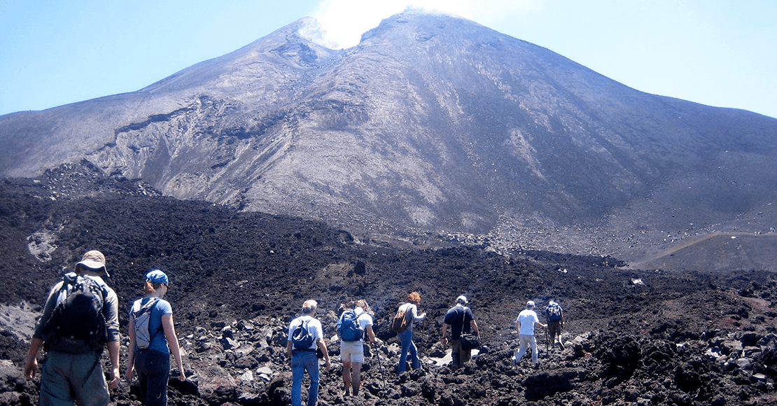 Hikers walking towards the volcano.