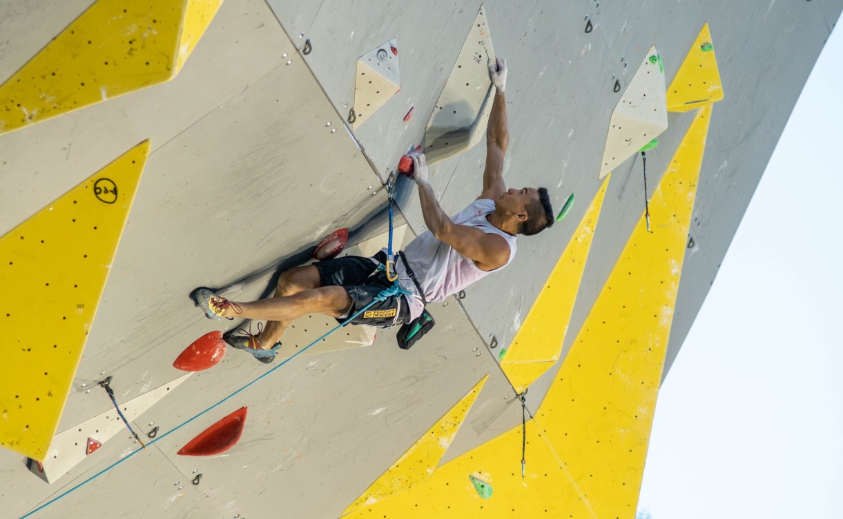 Sean McColl climbs up a wall.