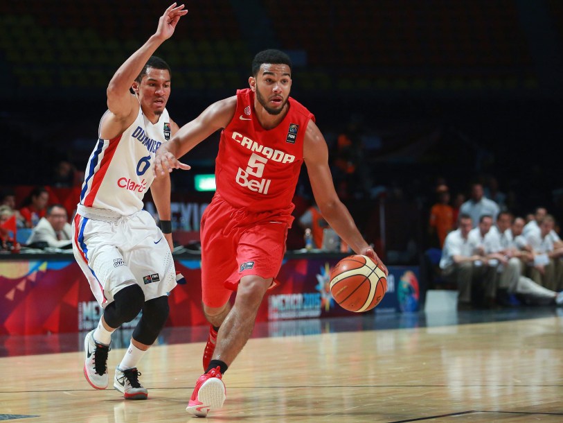 Canada's Cory Joseph, right, dribbles past Dominican Republic's Rigoberto Mendoza