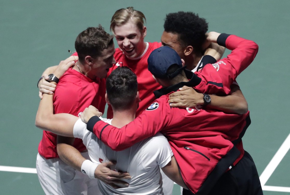 Canada's Davis Cup team members group hug after a win 