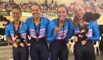 The women's team pursuit squad poses for a photo with their bronze medals.