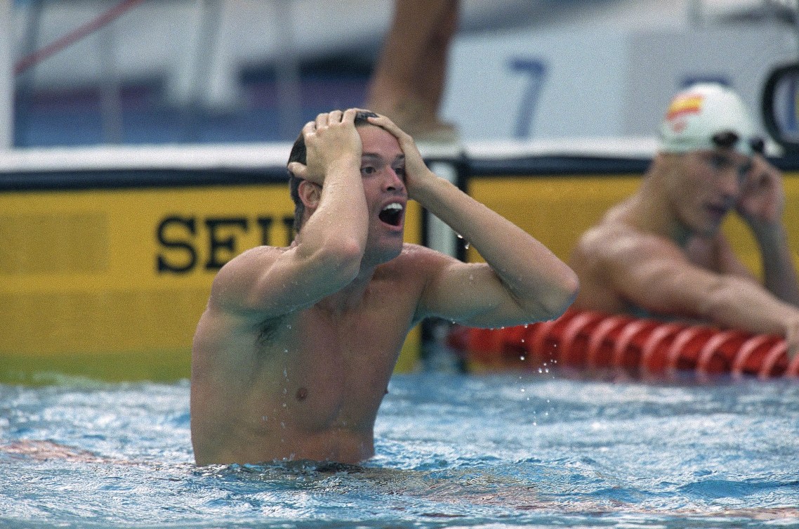Mark Tewksbury puts his hands to his head in shock at the end of the pool 