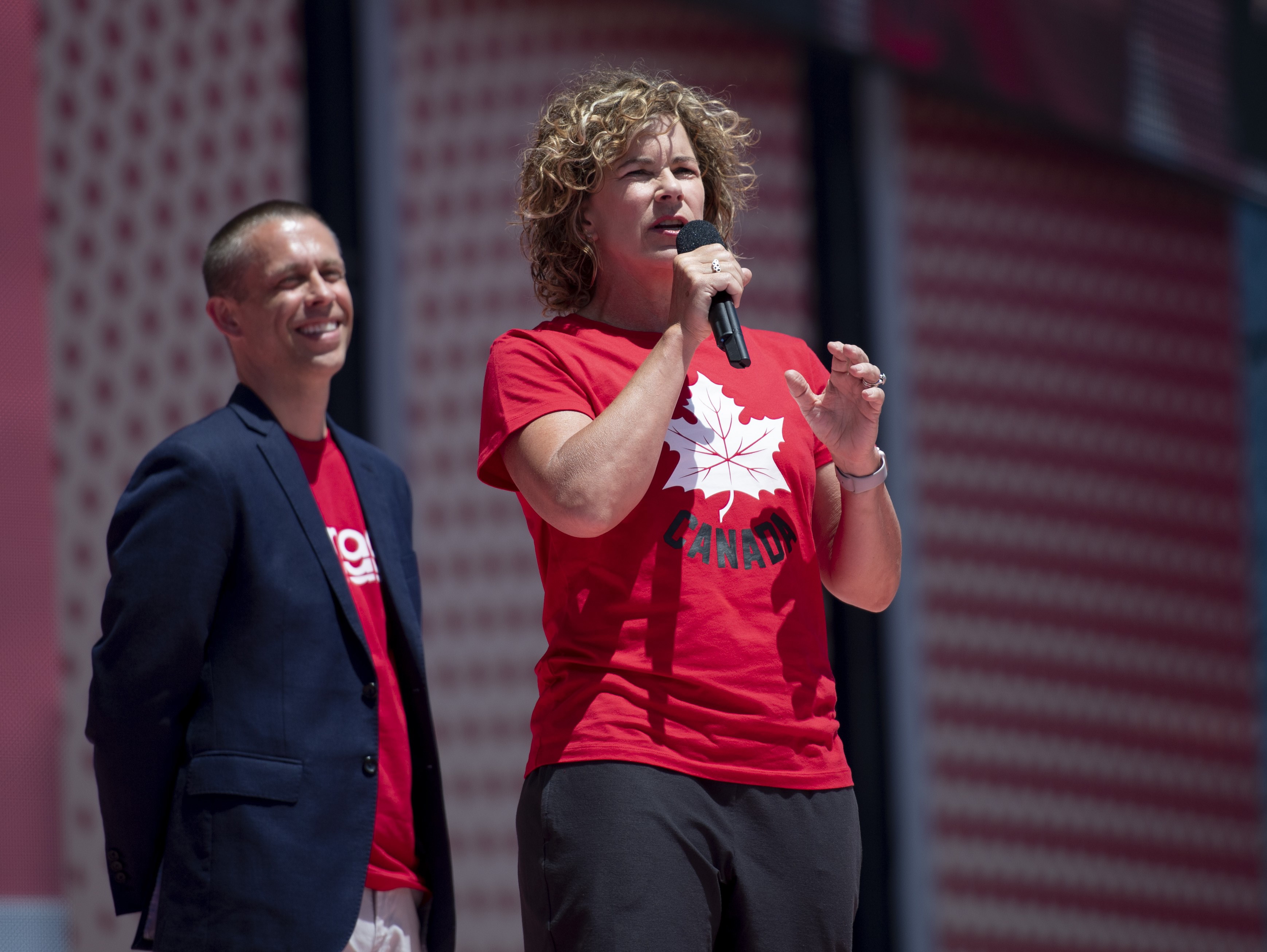 McBean speaking on stage in Team Canada gear 